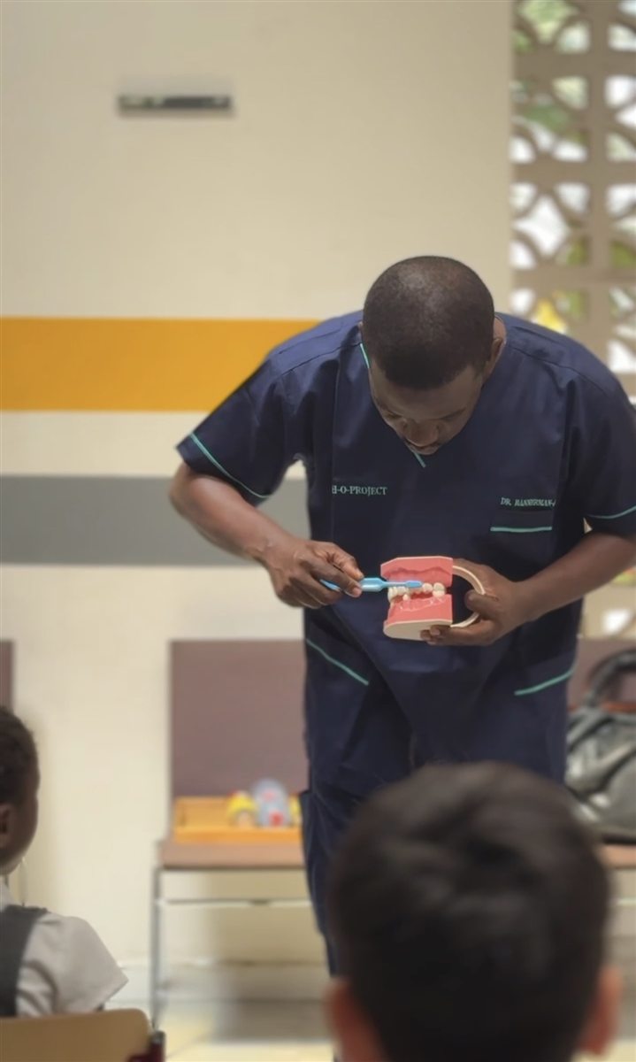 A dentist teaching Wild Card Club children how to care for their teeth